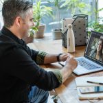 man in black sweater using macbook pro