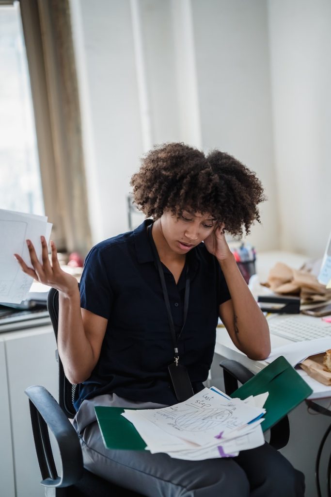 Woman Looking Through Documents and Making a Confused Facial Expression