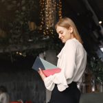 Smiling businesswoman reading notes in planner in cafe