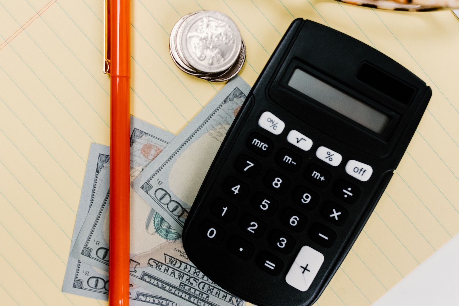 Orange Pen Beside Black Calculator