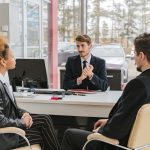 Man in a Suit Talking with a Couple in an Office