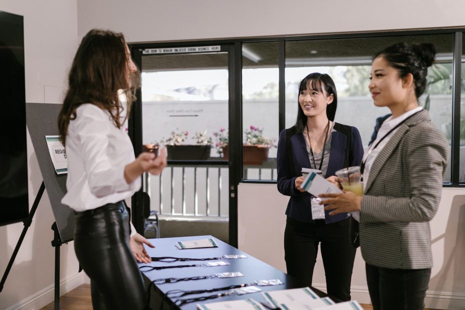 Women Standing by the Registration Booth at a Business Conference