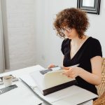 Woman in Black V-Neck Shirt Reading Documents