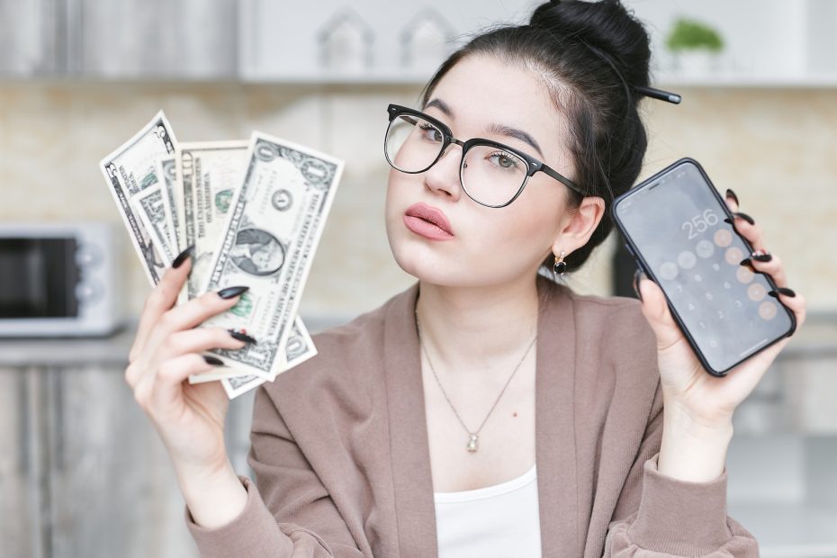 A Woman holding Smartphone and Money