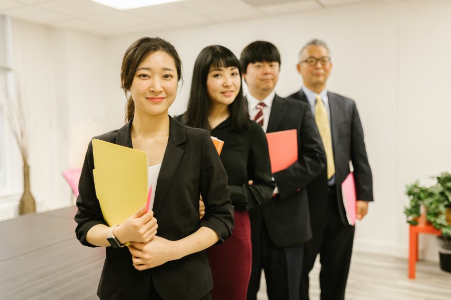A Woman Posing with her Coworkers at an Office
