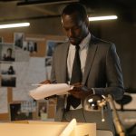 Man in Black Suit Jacket Reading a File