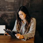 Ohio Secretary of State: The Roles and Responsibilities for Businesses woman wearing white dress shirt using holding black leather case on brown wooden table
